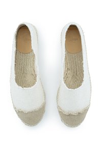 Espadrillas di tela bianca con punta in tessuto beige, suola in juta testurizzata e bordi sfilacciati. L'interno presenta una soletta di colore beige chiaro.
