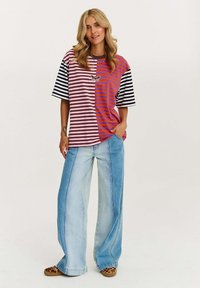 T-shirt w paski z wielokolorowymi panelami w odcieniach różu, brązu i pomarańczu, z czarno-białymi paskami na rękawach; lekki materiał.