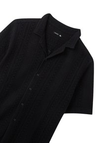 Maglietta nera a maniche corte con design lavorato a maglia e texture, caratterizzata da un tessuto a motivo e chiusura con bottoni. L'etichetta riporta "TERRANOVA" taglia XL.