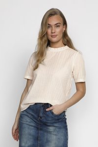 Top a manica corta a righe pesca e bianco con scollatura a volant, abbinato a una gonna di denim. Il tessuto sembra leggero e con una texture.