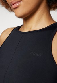 Juodas sportinis marškinėlis su uždaromu dizainu, glotnia medžiaga ir subtiliu "BORG" logotipu priekyje. Be matomų raštų ar detalių.