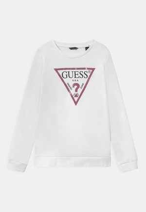 Sudadera blanca de manga larga y cuello redondo. Presenta un logo triangular de purpurina rosa con "GUESS U.S.A." y texto en su interior.