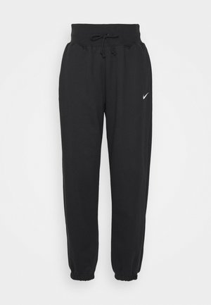 Schwarze Jogginghosen aus weichem Baumwollmix, mit elastischem Bund und Kordelzug sowie elastischen Bündchen. Nike-Logo am linken Oberschenkel.