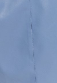 Svetle modrá kožená textura s hladkým povrchem, s vertikálním ševem podél povrchu. Žádné další akcenty.