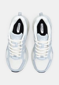Scarpe sportive azzurro chiaro realizzate in mesh e materiali sintetici. Le caratteristiche includono lacci bianchi, collo imbottito e suole interne nere con marchio.