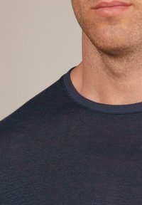 Mörkblå crew-neck t-shirt med en strukturerad yta, med en ribbad krage och en enkel, ren design.