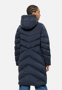 Marineblaue Steppjacke mit einem Chevron-Muster, Kapuze und gestepptem Material. Verfügt über ein langes Design und lange Ärmel, geeignet für kaltes Wetter.