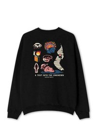 Sudadera negra con un diseño gráfico que presenta diversas ilustraciones coloridas, incluyendo ojos, un cerebro, fuego y el texto "UN VIAJE AL DESCONOCIDO."