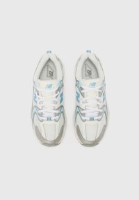 Weiße Laufschuhe mit hellblauen Akzenten, aus Mesh-Material, einer strukturierten grauen Sohle und weißen Schnürsenkeln. Mit Branding an der Zunge.