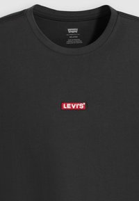 Tricou gri cu maneci scurte, realizat din bumbac, cu un mic logo din bumbac roșu brodat Levi's în zona pieptului. Guler clasic de tip crew.