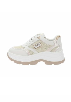 Zapatilla deportiva gruesa blanca y beige con laterales de malla, cordones blancos, suela gruesa y detalles metálicos, incluyendo una placa con el logo "4US" en el lateral.