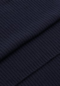 Námorná rebrová pletenina s textúrovaným vzorom a vertikálnymi pruhmi, ktorá zobrazuje jemný a teplý vzhľad.