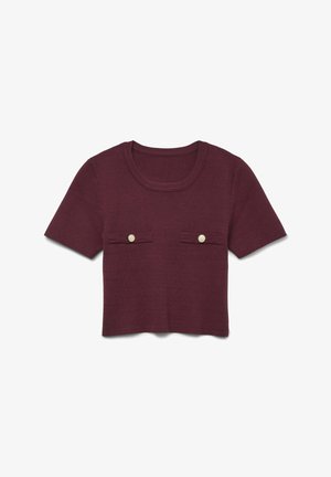 Kratke rokave, burgundska pletena majica z okroglo izrezom in dvema majhnima sprednjima žepoma okrašenima z zlatimi gumbi. Mehka tekstura, skrajšana zasnova.