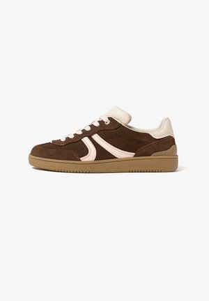 Brown suede sneaker with cream accents, white laces, and a gum rubber sole, shown from the outer side on a white background.