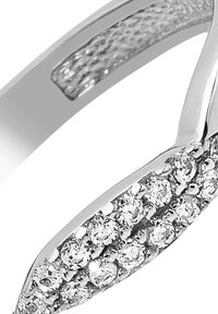 Bague en argent avec un anneau texturé à finition lisse et une rangée de pierres claires étincelantes disposées en ligne courbée sur un côté.