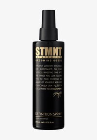 Svart sprayflaska med matt finish och guldtext. Etiketten lyder "STMNT GROOMING GOODS DEFINITION SPRAY" med en handskriven signatur. 200 ml.