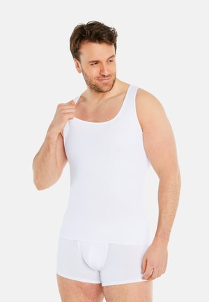 Weißes Baumwoll-Top ohne Ärmel mit Rundhalsausschnitt, kombiniert mit weißen Unterhosen. Der Stoff wirkt glatt und eng anliegend.