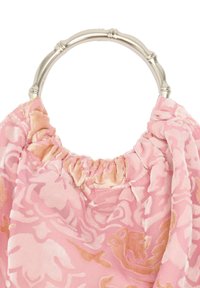 Różowa torebka z materiału z aksamitnym kwiatowym wzorem i okrągłym uchwytem w stylu bambusowym w kolorze srebrnym na białym tle.