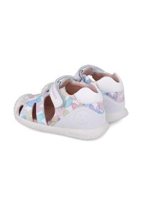 Sandali bianchi e nei colori pastello con sezioni sagomate, cinturino regolabile e suola texturizzata. Progettati per comfort e traspirabilità.