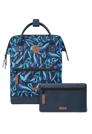 Blue patterned backpack with green and white leaf designs, front zipper pocket, and matching blue zippered pouch with leather accents.