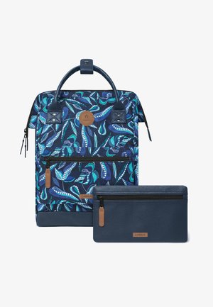 Blue patterned backpack with green and white leaf designs, front zipper pocket, and matching blue zippered pouch with leather accents.