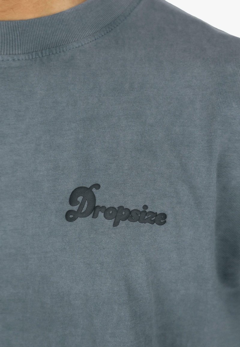 Sivá bavlnená mikina s okrúhlym výstrihom a textúrovaným čiernym logom "Dropsize" na hrudi. Hladká tkanina a neformálny dizajn.