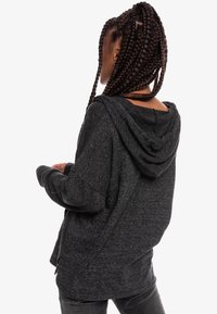 Felpa con cappuccio grigia scura realizzata in morbido tessuto, caratterizzata da una vestibilità rilassata, spalle scese e un cordoncino regolabile sul cappuccio.