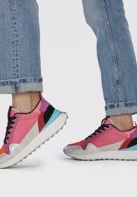 Zapatillas coloridas que presentan materiales en contraste en rosa, plata y azul, con una textura mixta, acentos estampados y un diseño deportivo.