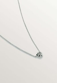 Collar de plata con un colgante redondo que presenta una gema transparente, complementado por un diseño de cadena delicada.