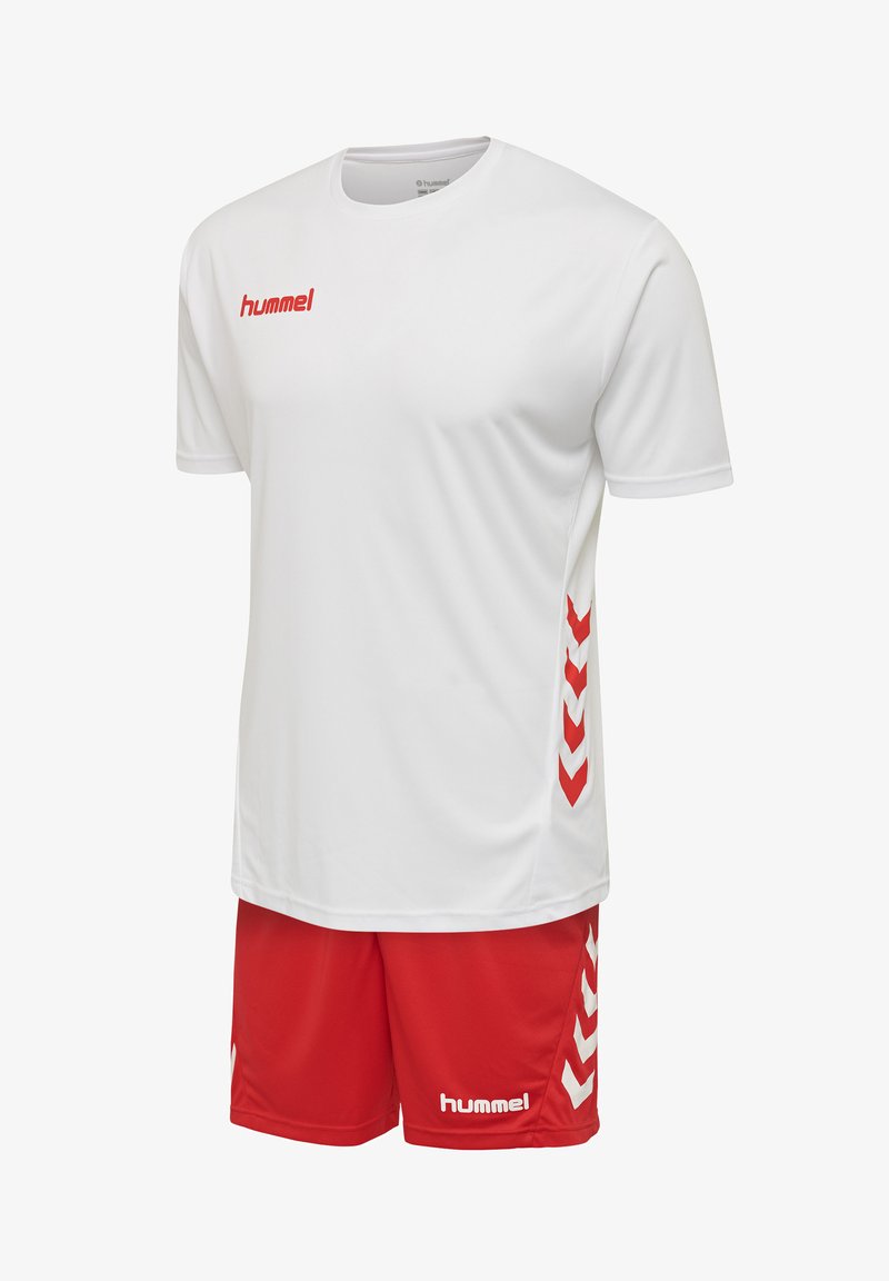Weißes Sportshirt mit rotem Logo und roten Shorts; verfügt über rote Chevron-Muster an den Seiten; aus atmungsaktivem Material hergestellt.