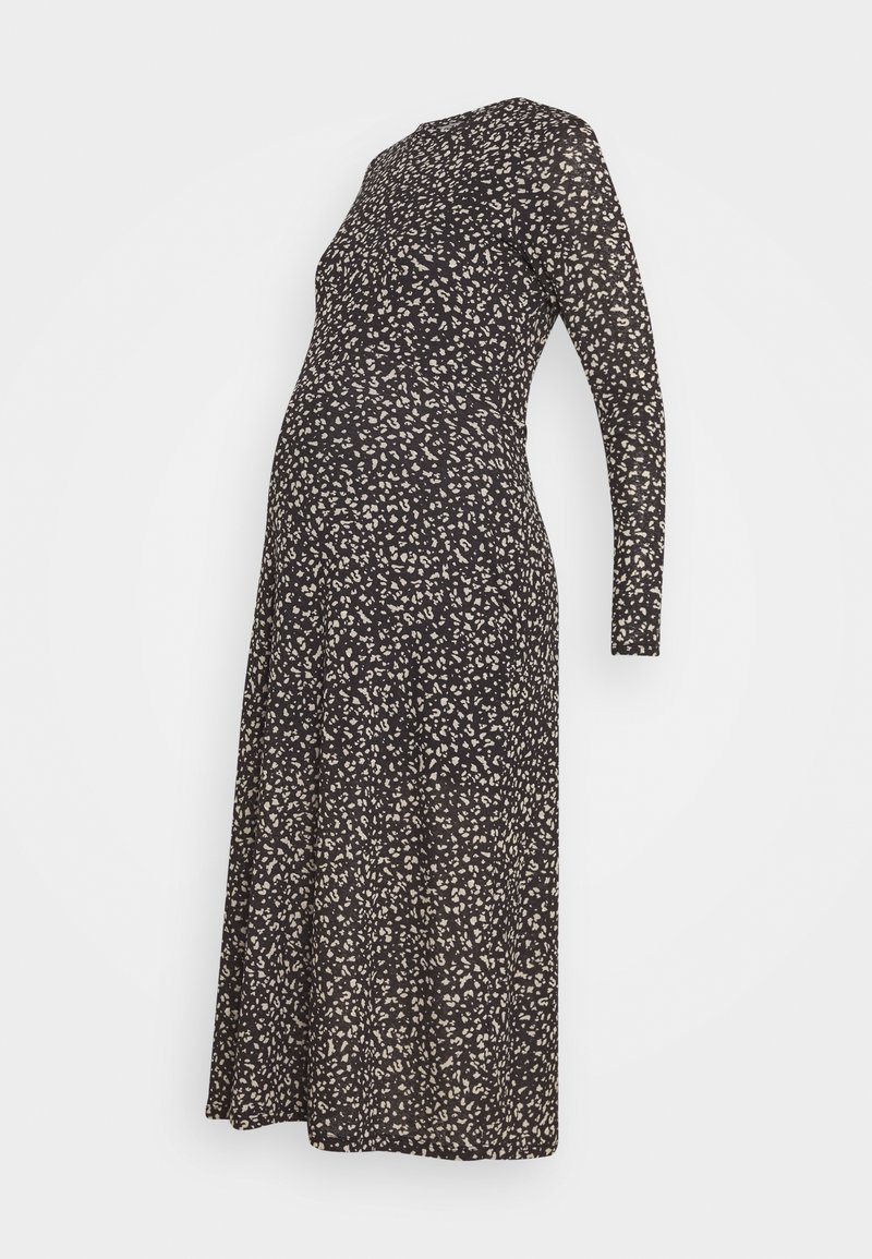 Mekko äitiyskäyttöön mustana, jossa on beige kukkakuvio, valmistettu pehmeästä kankaasta, pitkät hihat ja vartalonmyötäinen muotoilu, joka mukautuu kasvavaan vatsaan.