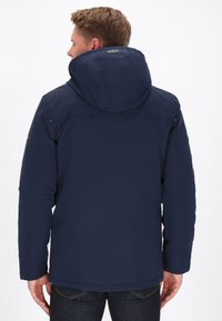 Marineblaue isolierte Jacke mit Kapuze, glatte Textur, taillierter Schnitt und Seitentaschen. Verfügt über Nähdetails an den Schultern.