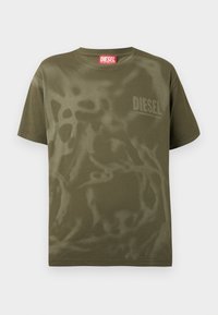 Βαμβακερό t-shirt σε ελιά πράσινο με άνετη εφαρμογή, διακοσμημένο με ένα διακριτικό αφηρημένο μοτίβο και μικρό λογότυπο "DIESEL" στο στήθος.