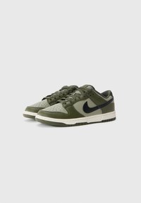 Grønne Nike sneakers med overdel i glat læder, sort swoosh, perforeret tå og cremefarvet mellemsål. Har flade snørebånd og en polstret krave.