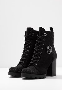Stivali neri alla caviglia con design in suede trapuntato, punta decorata con cristalli, hardware in argento e tacco alto bulky.
