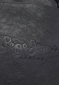 Borsa in pelle nera con logo embossato "Pepe Jeans London". La superficie presenta una finitura texturizzata con un leggero motivo a grana.