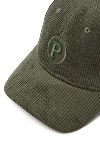 Green corduroy cap featuring a rounded brim, textured ridges, and an embroidered circular logo with a "P" on the front.