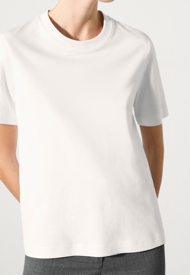 White cotton t-shirt with a round neckline and short sleeves, featuring a relaxed fit and smooth texture, no visible patterns or accents.