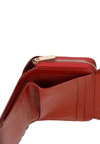 Rood leren portemonnee met een ritscompartiment, meerdere kaartsleuven en een gestructureerde afwerking. Beschikt over gouden hardware accenten.