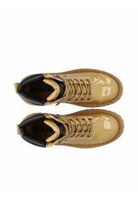 Bottines hautes en cuir verni beige brillant avec des accents en textile noir. Comprend un laçage à l'avant, un col rembourré et une semelle en caoutchouc texturée.