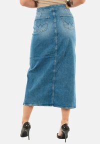 Jeansrok met een middellange lengte, lichtblauwe kleur, twee achterzakken met gestikte accenten en een rechte silhouet.