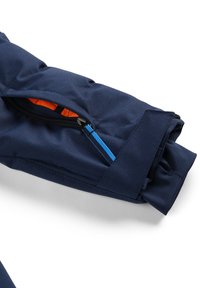 Marinejacke mit einem Ärmel, der eine orangefarbene Reißverschlusstasche und einen blauen Reißverschluss hat. Besticht durch strapazierfähigen Stoff und eine glatte Textur.