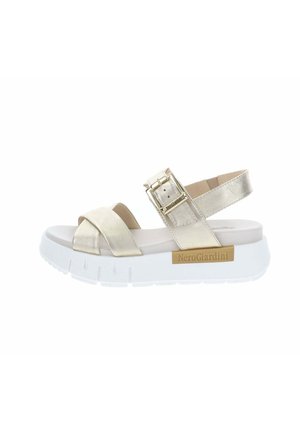 Sandalo beige con suola bianca spessa, ampi cinturini frontali, cinturino regolabile con fibbia alla caviglia e logo NeroGiardini sul lato.