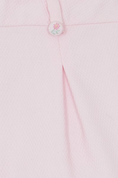 Ελαφρώς ροζ ύφασμα με υφή από πλεκτό μοτίβο βάφλας. Ένα μικρό, κεντητό λουλουδάτο κουμπί αναδεικνύει τη ριγωτή λεπτομέρεια στο μπροστινό μέρος.