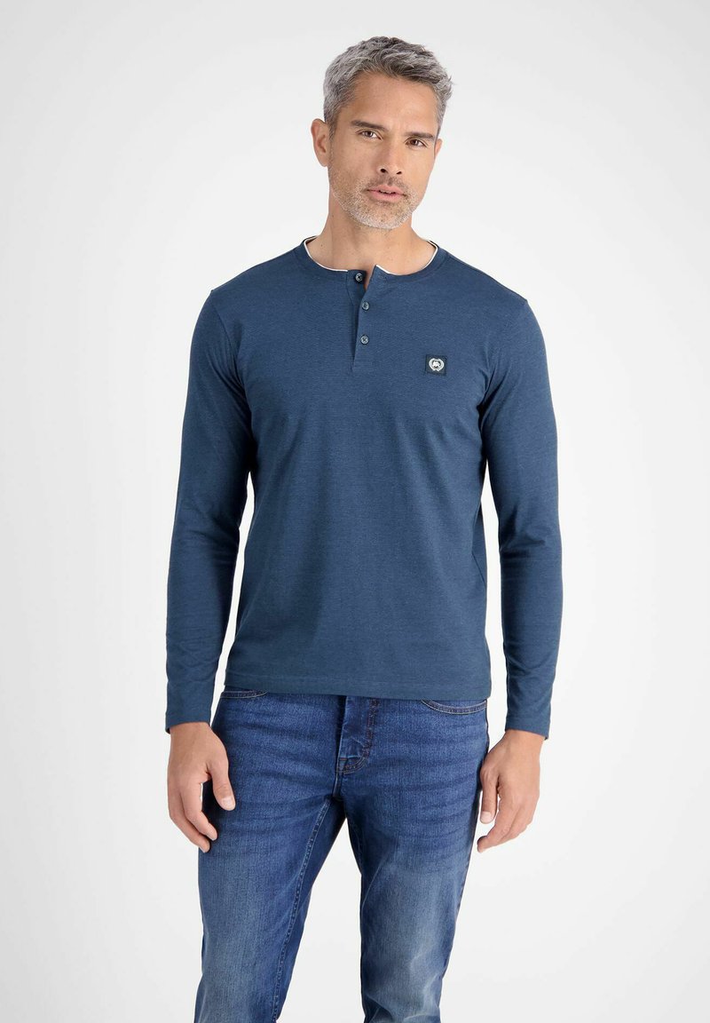 Blaue Langarm-Henley-Bluse aus strukturiertem Stoff mit rundem Halsausschnitt und Knopfleiste mit drei Knöpfen. Mit einem Logo-Patch auf der Brust.