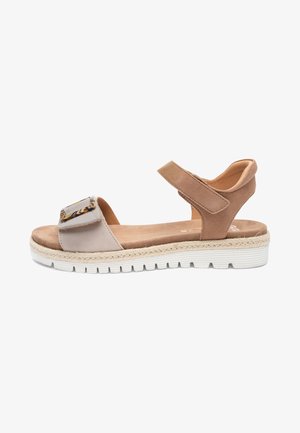 Beige and taupe open-toe sandal with adjustable ankle and front straps, cushioned sole, and white textured outsole.