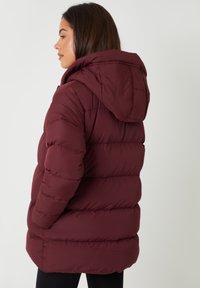 Burgunderfärgad puffjacka med huva, med en kviltad design, tjock isolering och sidofickor, som visar en slät och blank yta.