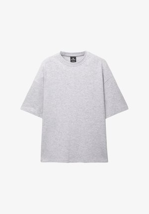 Grau kurzärmliges T-Shirt aus weichem Stoff; verfügt über einen runden Ausschnitt und einen lässigen Schnitt mit fallenden Schultern. Keine Muster oder Akzente vorhanden.