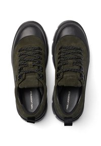 Žalios suede sportbačiai su juodais guminiais akcentais, apvaliu pirštu, tekstūruotomis raištelėmis ir kilputė. Vidinėje pado pusėje esantis logotipas.