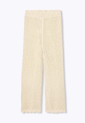 Pantalons larges en tricot de couleur crème, avec une texture en tissage ouvert et un ourlet festonné. La taille élastique offre un ajustement confortable.